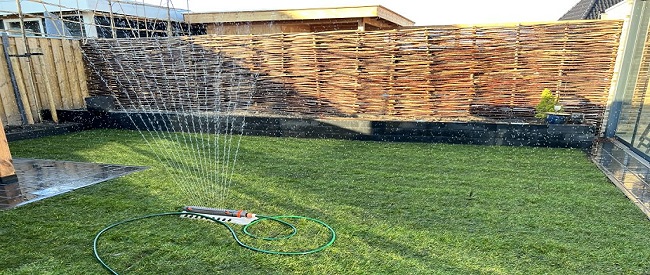 Nieuw gazon sproeien na het leggen van graszoden